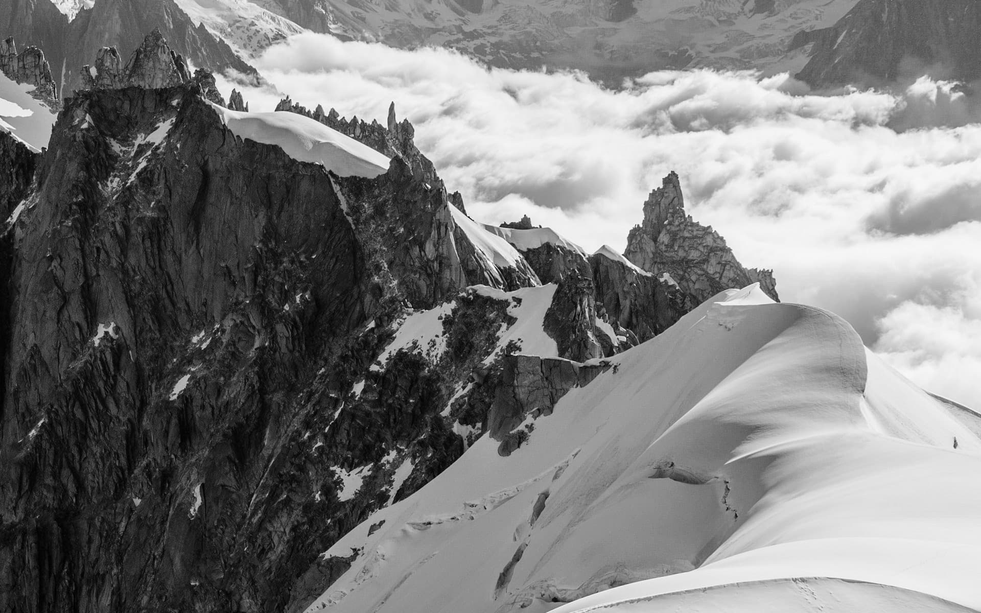 Snow-covered alpine ridge above the clouds near Chamonix, Mont Blanc massif